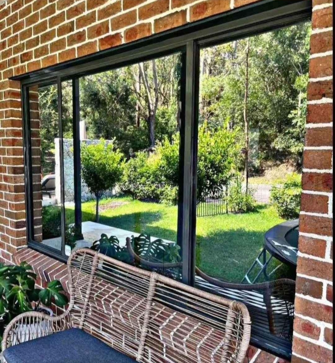 Reflective window tint on black frame glass doors brick home by TMC Tinting Sydney — privacy heat UV 0449 582 777