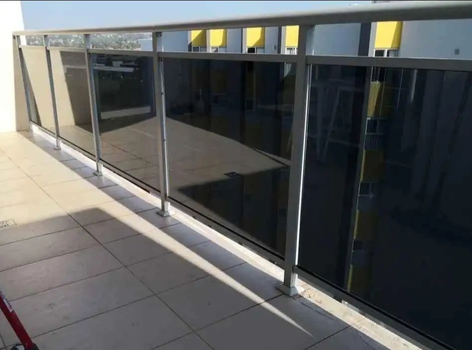 Dark tinted verandah glass panels in Sydney high-rise apartment by TMC Tinting — apartment specialist call 0449 582 777