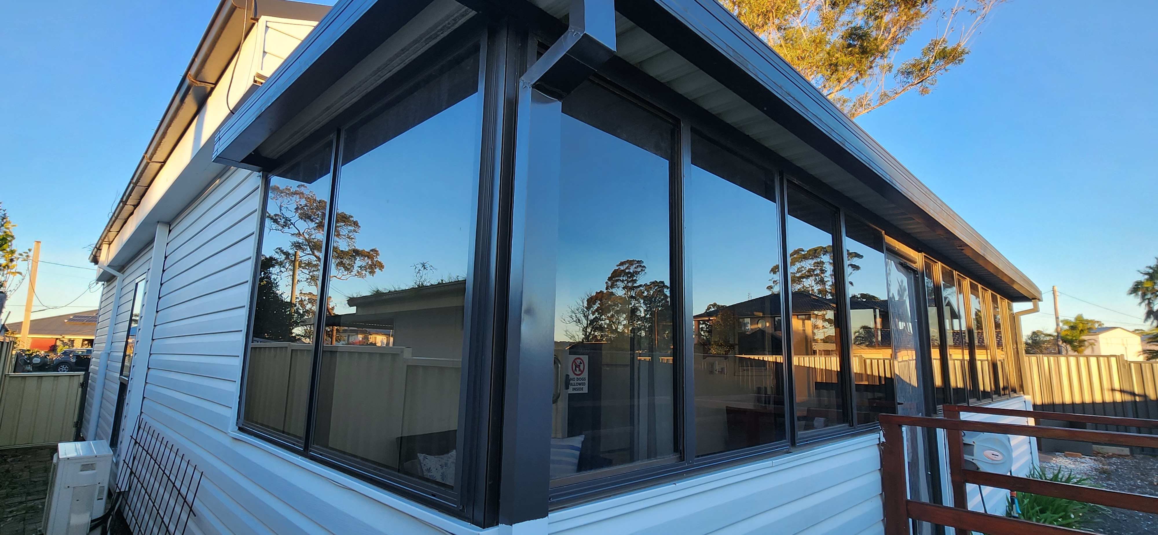 light shade window tint applied to sunroom enclosed patio area at basin view south coast for a client to reduce heat and glare whilst maintaining natural sunlight making it a comfortable stay for those that book his holliday rental down south coast near jarvis bay