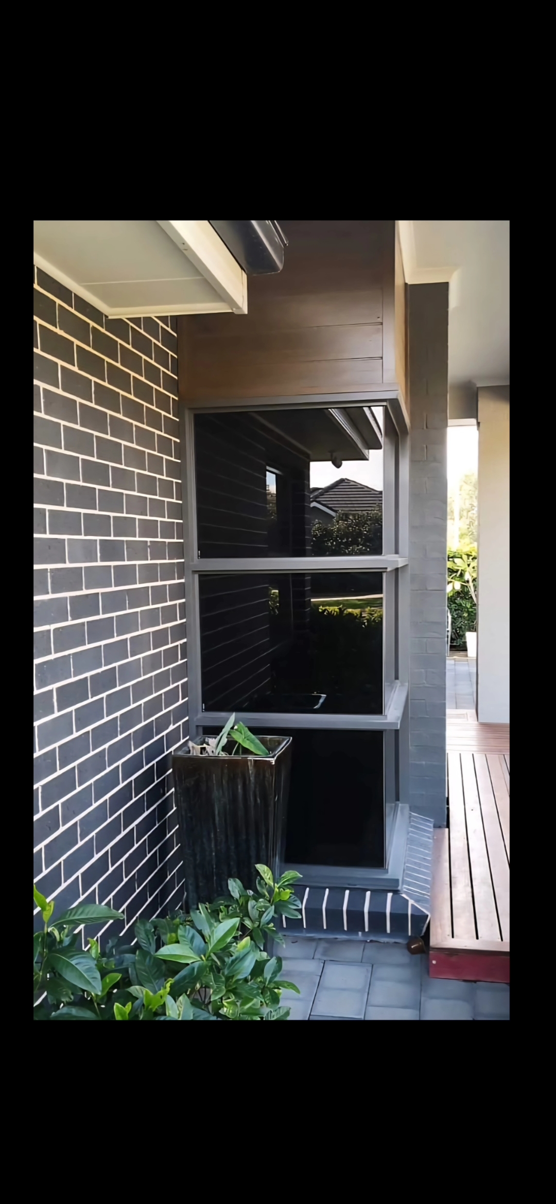 Dark charcoal window tint on modern black brick home by TMC Tinting Sydney — privacy & heat control 0449 582 777